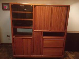 lot 978 image: Oak Entertainment Center with Smoky Glass Doors, VHS Tape Holder and Storage Drawers.   T.V. NOT INCLUDED.  63 x 60 x 21.   Located in basement