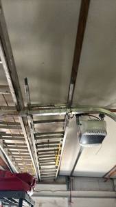 lot 4248 image: 22ft Extension Ladder with Safety Bar.  Located on ceiling and garage you will need to bring another ladder to remove it.