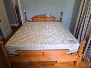lot 116 image: Solid Wood King Size Bed with Boxspring, Nice Clean Pillowtop Mattress, Headboard, Footboard, rails, and understorage that is missing one drawer.