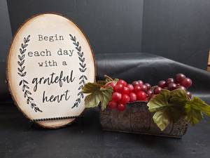 lot 174 image: Wood Slice Wall Art Sign Begin Each Day with a Grateful Heart, Metal Bowl, and Plastic Grapes