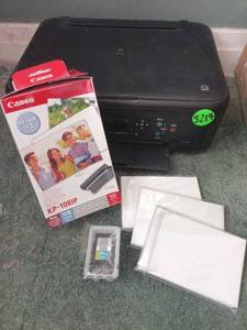 lot 5214 image: The Canon PIXMA TS5120 is a compact, wireless all-in-one inkjet printer ideal for budget-conscious home users. It prints vivid photos, scans documents, and copies. It retails between $200 and $300