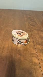 lot 145 image: Oval Tin Container with Illustrated Figures and Handle