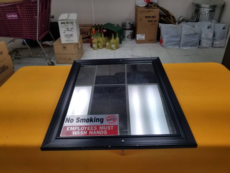 lot 6378 image: Black Framed Mirror 19x23 w No Smoking Sign