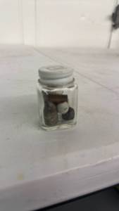 lot 14 image: Small Glass Jar with Lid Containing Assorted spent rounds