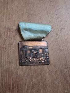 lot 2001 image: Rectangular Medal with Train Scene Relief and Green Ribbon Pin Back