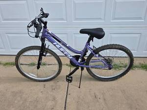 lot 463 image: Huffy 24 Rock Creek womens mountain bike. Appears in near new condition. Needs back tire repair.