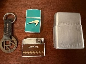 lot 526 image: Vintage Marlboro Keychain, Newport and Camel Lighters and Cigarette Case in a Cigar Box