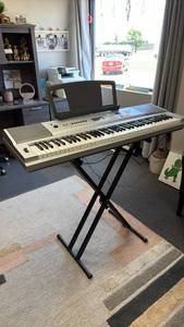 lot 100 image: Yamaha Portable Grand DGX-230 electric keyboard with stand and music books