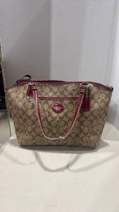 lot 1005 image: Coach handbag with red trim and silver hardware, straps are worn a little inside needs cleaned