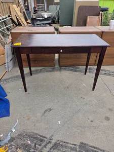 lot 25171 image: Dark wood writing desk featuring a single center drawer and slim tapering legs