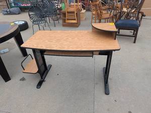 lot 25180 image: Light wood-laminate computer desk with a black metal frame and an integrated elevated corner shelf.