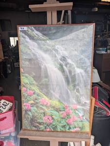 lot 73 image: Framed picture of a waterfall cascading over rocks with pink flowers along the lower edge.