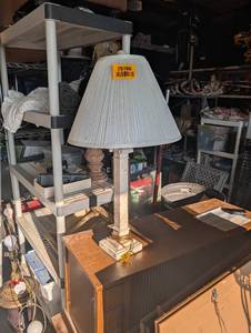 lot 25186 image: Vintage-style table lamp featuring a pleated conical shade and a slender, brass-accented column base