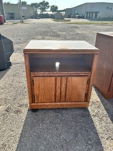 lot 92 image: Compact wooden media cabinet featuring an open upper shelf and vertically paneled lower cabinet doors