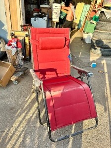 lot 128 image: Red folding zero-gravity outdoor patio recliner with a matching headrest pillow