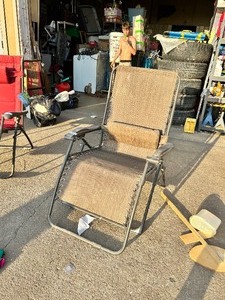 lot 129 image: Folding zero-gravity reclining patio lounge chair with brown mesh sling seat and adjustable matching headrest pillow