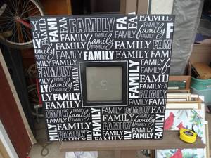 lot 56 image: Square black-and-white picture frame patterned with repeating FAMILY typography and a central photo window