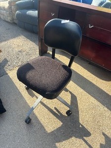 lot 99 image: Black rolling office task chair with an upholstered fabric seat, a curved vinyl backrest, and a metal wheeled base