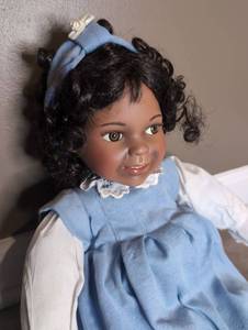 lot 801 image: Doll with Black Hair Blue Dress White Collar and Headband