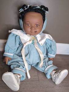 lot 802 image: Infant Doll with Black Hair Blue Outfit White Bonnet