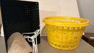 lot 1643 image: Plastic Laundry Basket Yellow and Black Mesh tote with hangers and a bath mat