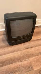 lot 2010 image: Symphonic 13 Inch TV with built in VHS player located in basement