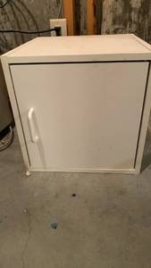 lot 2101 image: White Single-Door Storage Cabinet with Magnetic Catch 15 x 15 x 15 located in basement