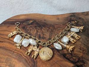 lot 3200 image: Gold Tone Charm Bracelet White Beads Eiffel Tower Castle Coin Pendant
