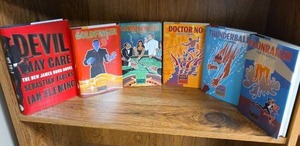 lot 715 image: Ian Fleming James Bond Classic Hard cover books - 5 from The James Bond Classic Library and a first edition of Devil May Care  (books may or may not have an Ex Libris this Book Belongs To sticker on first page)