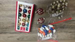 lot 546 image: Christmas Ornaments, two glass peppermint candy oil candles, and a bag of light bulbs