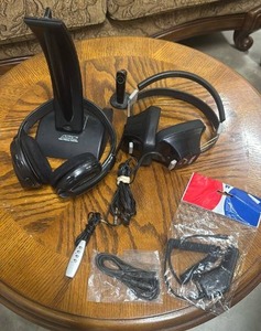 lot 310 image: Arkon Radio Frequency Transmitter Wireless Headphones with stand, another pair of headphones and electric cords