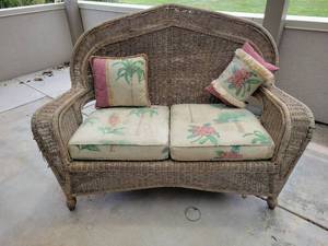lot 610 image: Wicker Loveseat with Floral Cushions and Throw Pillows