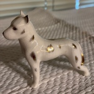 lot 3022 image: This is a charming vintage Royal Copenhagen white porcelain dog figurine adorned with hand-painted gold luster accents and spots.