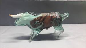 lot 2002 image: Vintage Murano-style mouth-blown art glass bull figurine features a striking brown and white swirled body with translucent green-tinted legs and contrasting white horns.