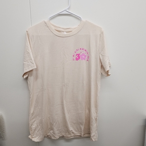 lot 3046 image: Cream-colored crewneck graphic t-shirt features a playful In My 30th Birthday Era chest design with vibrant pink lettering and a matching flower icon. Large