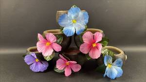 lot 117 image: 6) Luau Candles Shaped Like Coconut Halves with Faux Hibiscus Flowers