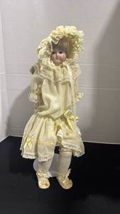 lot 1004 image: Bisque head Doll Cream Lace Dress Yellow Ribbons 19 inches tall