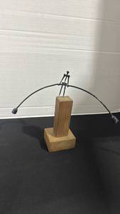 lot 1010 image: MCM kinetic balancing tightrope walker sculpture features a metal wire figure on a wooden pedestal 10 inches tall