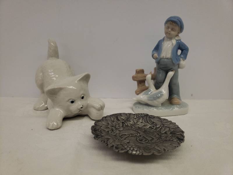 lot 125 image: Vintage Porcelain Figurines White Kitten with Ball of Yarn Stamped Brazil, Boy with Geese Made by Lego with Original Sticker 6in T, and Vintage Pewter Grapevine Autour Du Vin Wine Cork Tray - with Original Foil Sticker