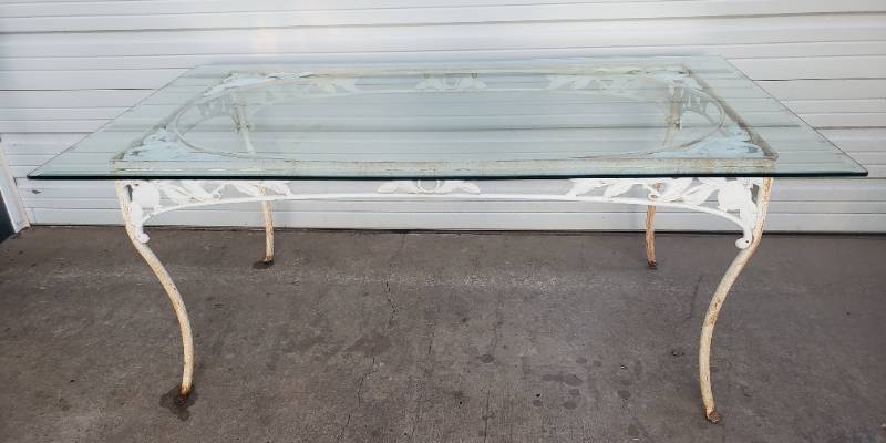 lot 50 image: Large Vintage White Iron PatioDining Table with Fruit & Leaf Apron Design -  Thick Beveled Edge Glass Top - 72in L x 42in W x 30in T - 2 Pcs - HEAVY - Bring Help to MoveLoad
