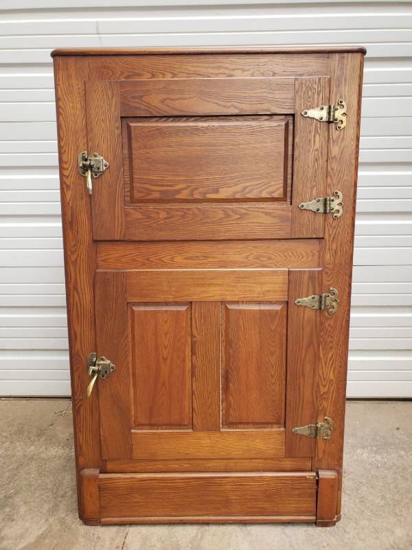 lot 6 image: Antique Early 1900s Oak Ice Box with Brass HandlesLatches & Hinges - Porcelain Over Metal Lined Lower Food Storage Box with Upper Ice Storage Compartment and Drainage Pan with Pipe to base - Original Sticker inside Lower Door - 31in W x 22in D x 51in T