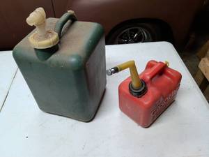 lot 820 image: Lot of 2 Fuel Cans Green and Red with Spouts. They do have something in it. Not for sure if its gas. Kind of smells like it but not for sure.