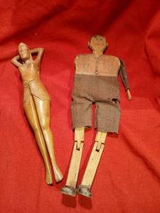 lot 1119 image: Vintage articulated wooden lady nutcracker and carved wooden man with cloth clothing missing arm as noted in picture.