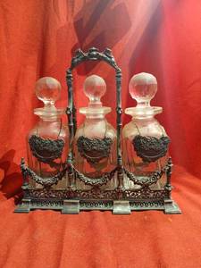 lot 1133 image: Vintage 3-Bottle  Decanter Stand with  caddy Glass Bottles and Stoppers silver plated