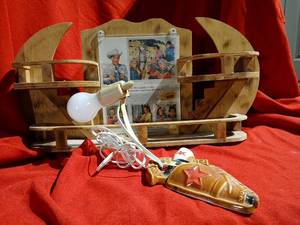 lot 1167 image: Vintage Cermic wall lamp gun and holster theme and Eastman  KodakCompany  Advertisement featuring  Roy Rogers, Dale Evans, and Trigger in homemade wooden trinket shelf 23 inches wide