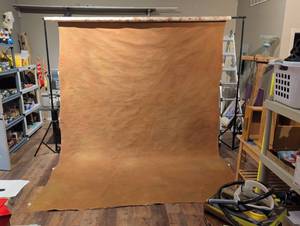 lot 1460 image: Two sepia brown painted muslin backdrops, 9ft wide by at least 15 ft long. On rolls. Bring a truck or suv.