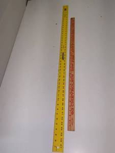 lot 1498 image: Yellow straight edge metal ruler and a vintage 63 Chevrolet yard stick