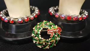 lot 150 image: Vintage Gold Tone Christmas Wreath Brooch with RedGreen Enamel & Rhinestones - 1.75in W, and 2 Silver Tone RedArora Borealis Stone Bangle Bracelets with Magnetic Clasps