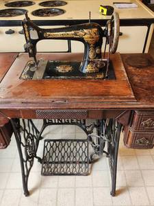 lot 81 image: Antique Singer Treadle Sewing Machine with Wood Cabinet and Iron Base Includes Original Manual &amp Several Attachments
