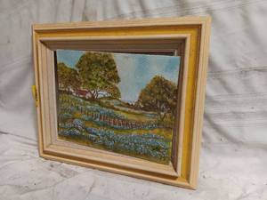 lot 33857 image: Framed vintage landscape painting, a field of bluebonnets in a rural setting with large trees under a blue sky.